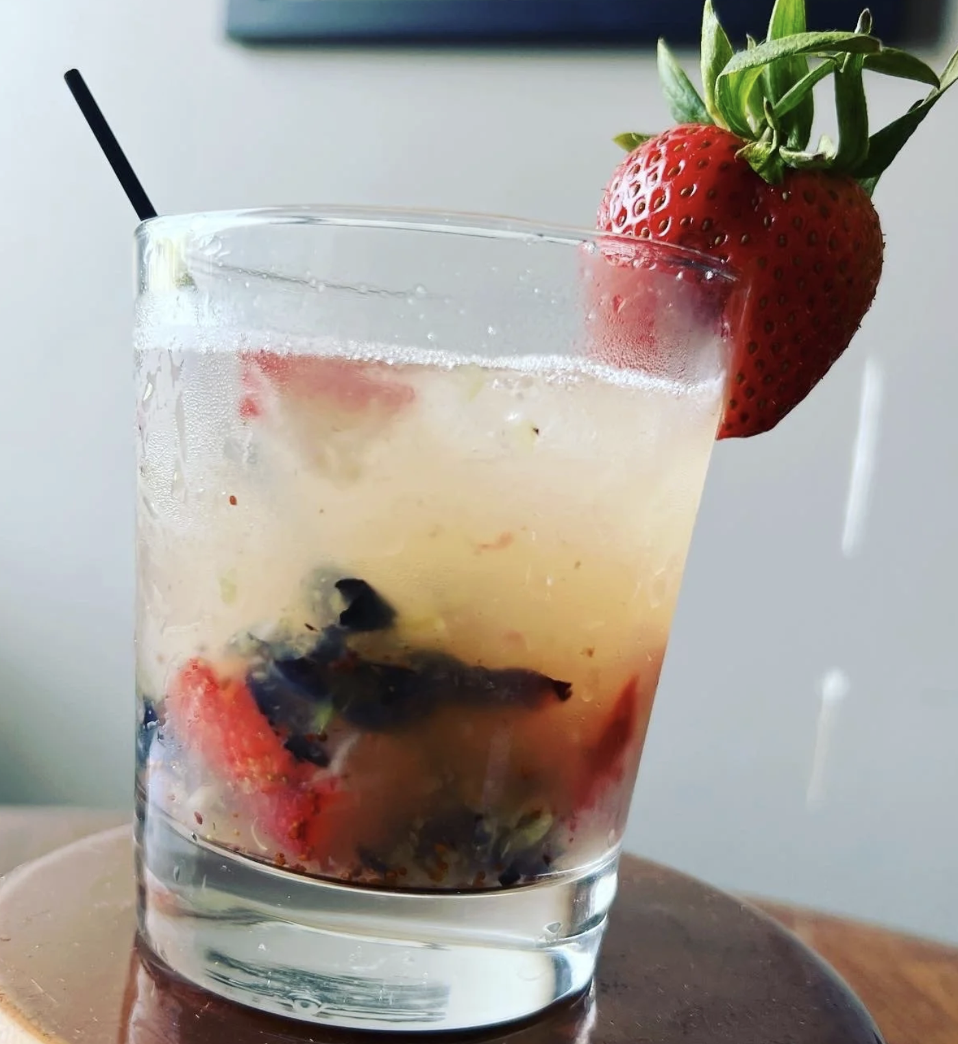 Craft cocktail garnished with fresh strawberry and basil