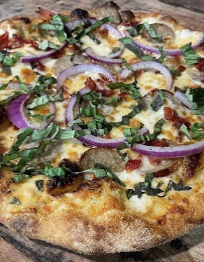 Brick oven pizza with sausage, red onion and fresh basil
